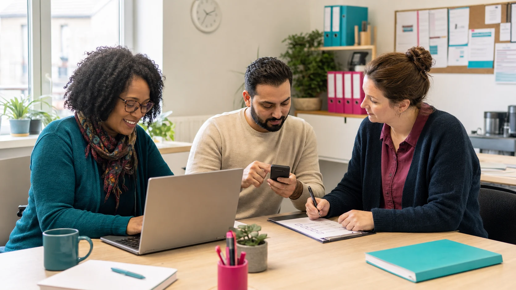 Illustrative image of charity colleagues working securely with a laptop, phone and checklist